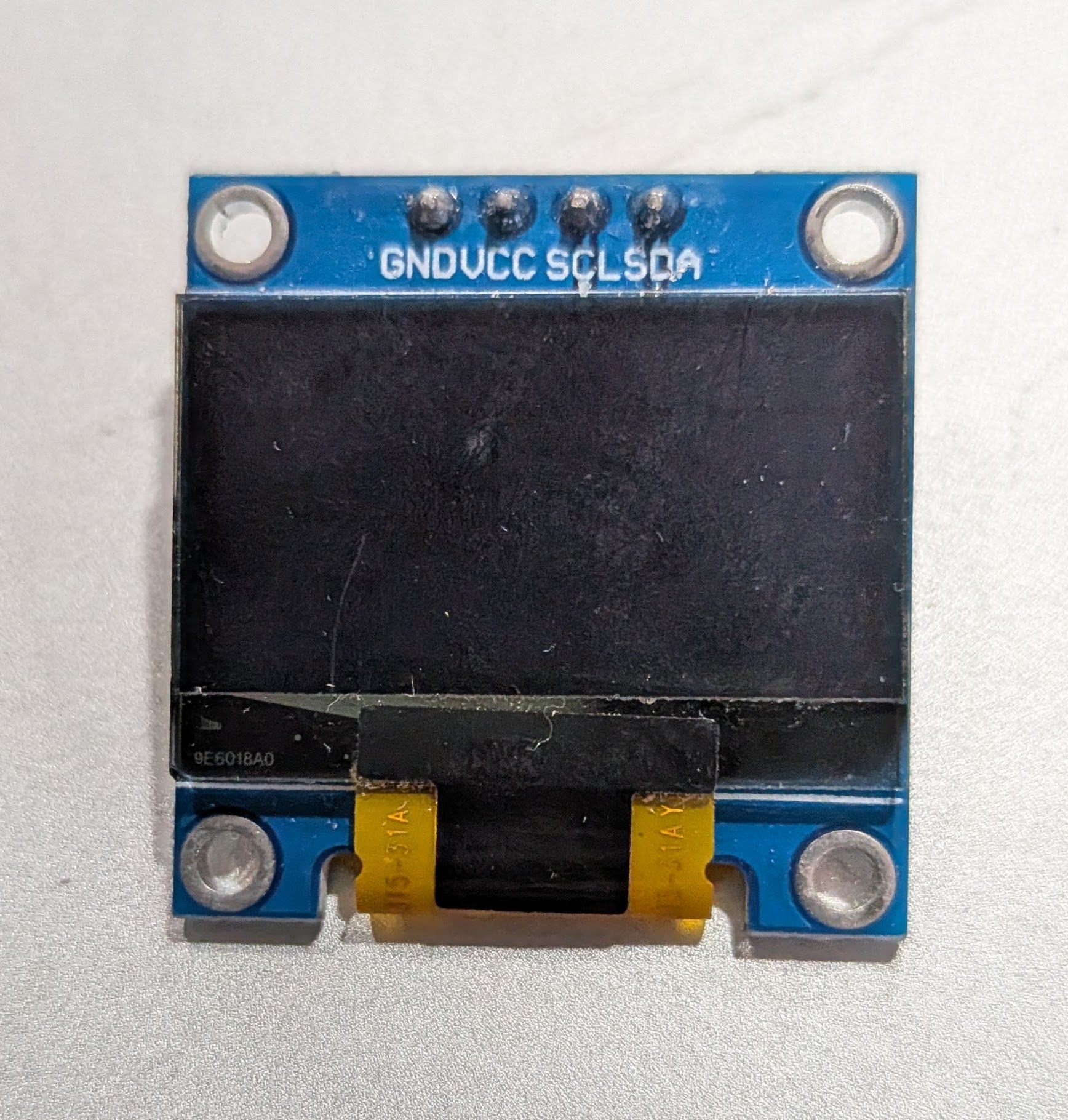 SSD1306 128x64 OLED module front face with GND VCC SCL SDA pin labels visible