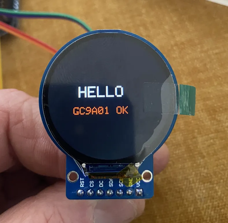 Working GC9A01 round TFT display wired to ESP32, showing HELLO in white text and GC9A01 OK in orange on a black background